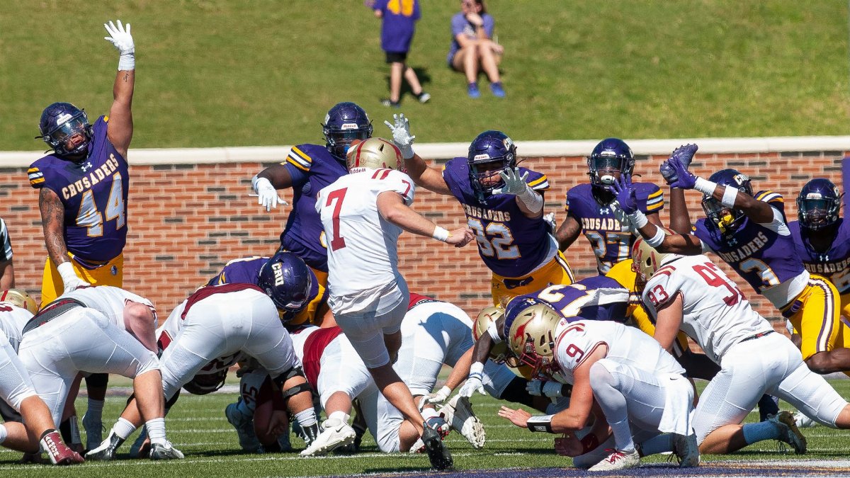Dynamic action shot of an American football game with players in colorful gear.