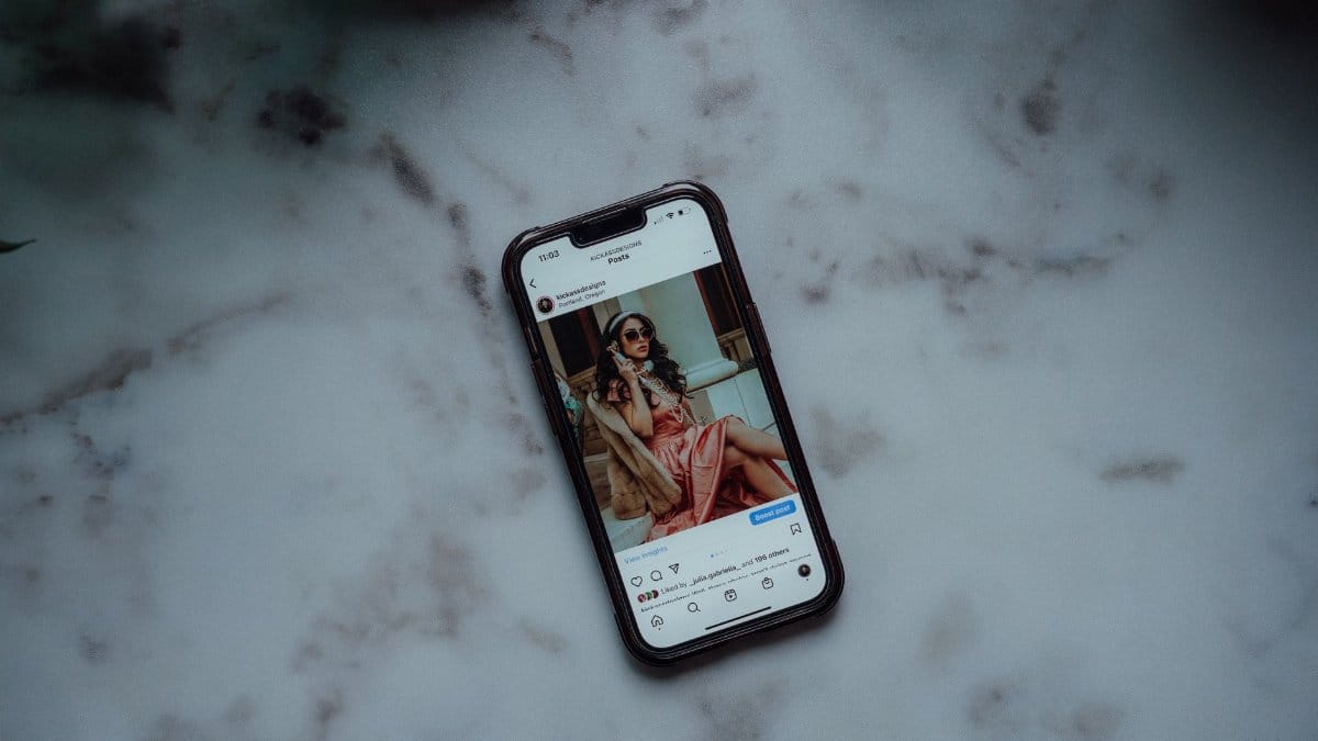 A smartphone showing an Instagram post against a marble background, showcasing modern social media use.