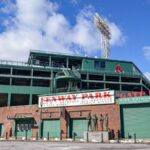 Iconic Fenway Park entrance on a clear day in Boston, showcasing historic architecture and vibrant atmosphere.