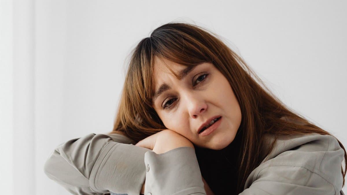 Close-up of a woman expressing sadness and emotional distress indoors.