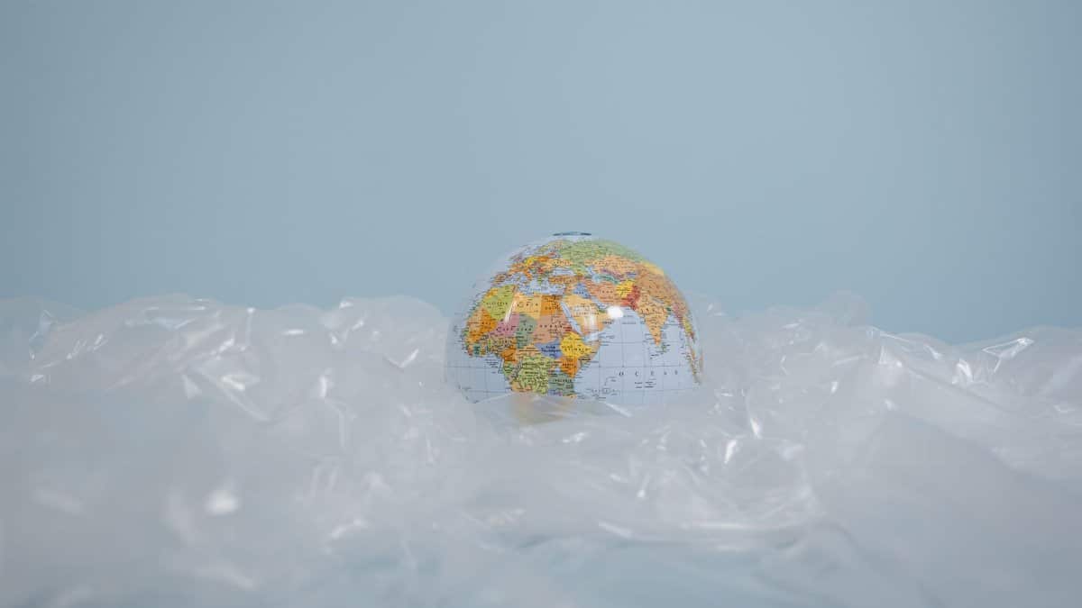 A globe surrounded by plastic, highlighting global environmental pollution issues.