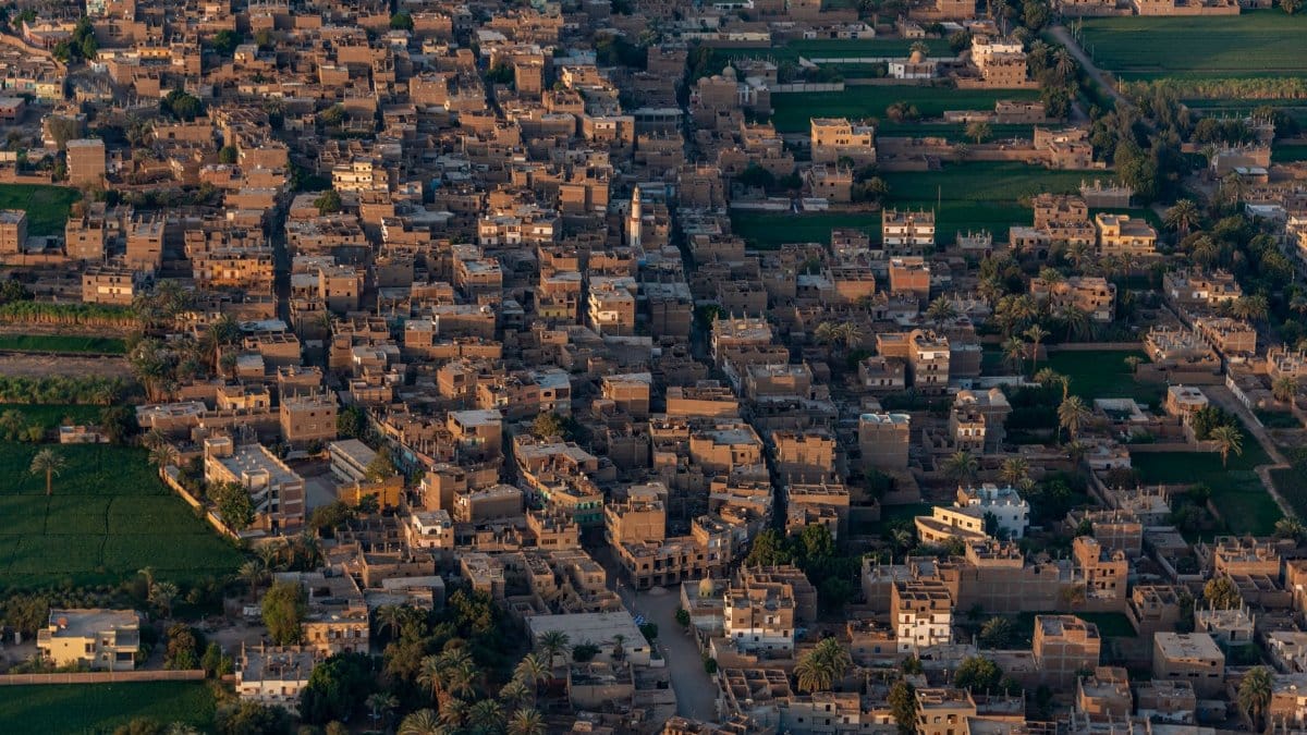 Aerial view of a densely packed village showcasing traditional architecture and surrounding greenery.