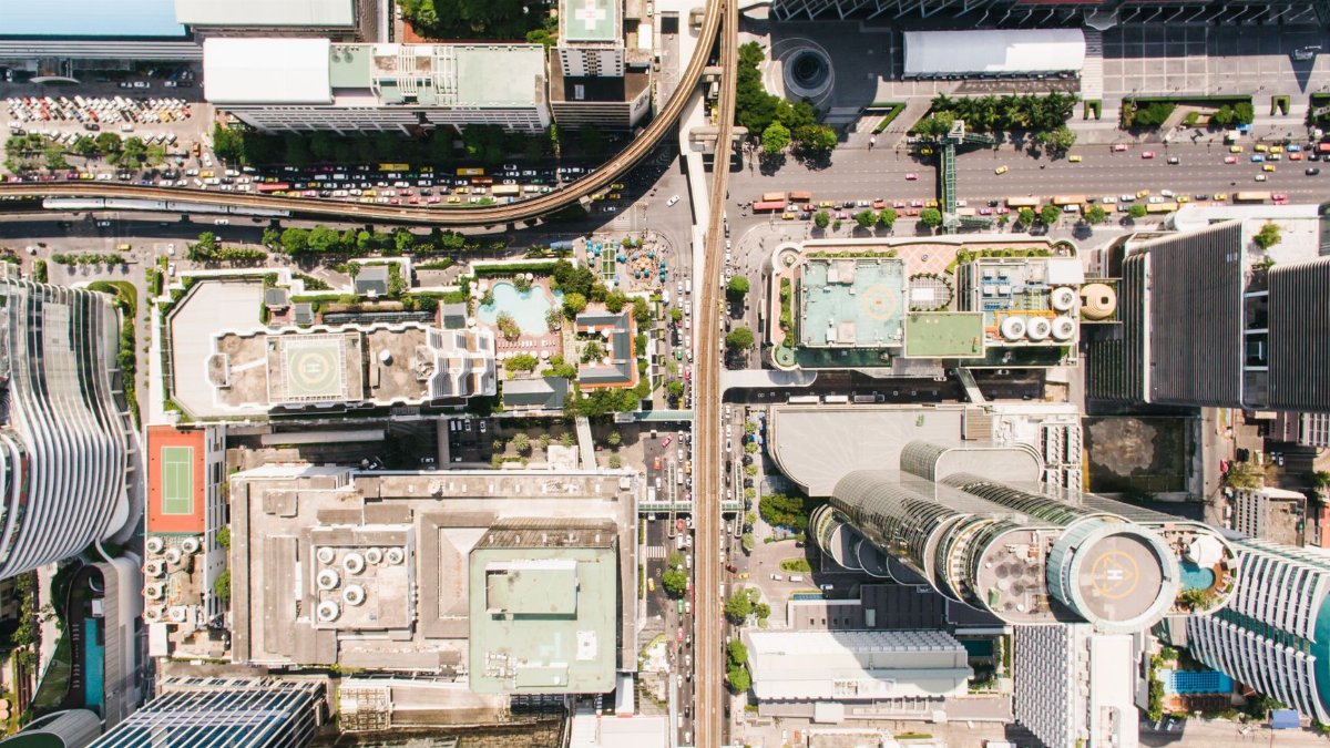 Aerial shot of a bustling city center with skyscrapers and roads, showcasing urban architecture.