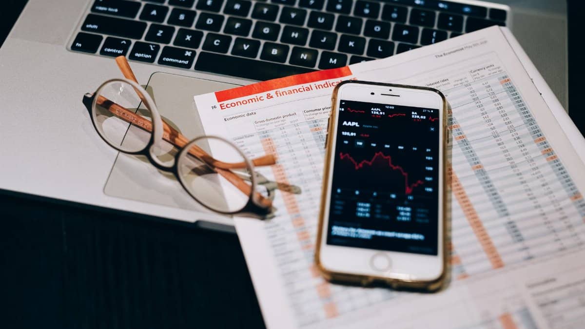 A detailed look at financial tools including a smartphone and laptop for stock analysis.