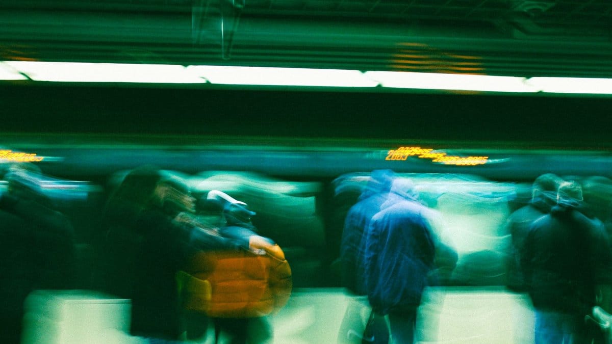 Abstract motion blur of commuters in a subway station, conveying movement and urban life.