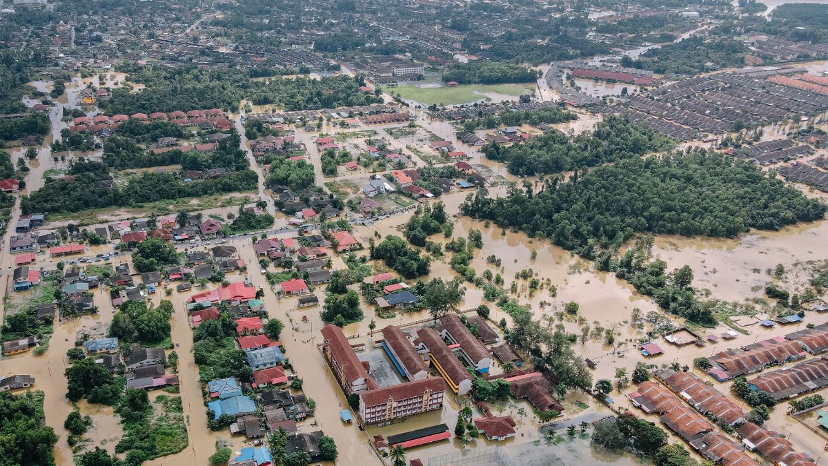 Aerial view of flooded small town with many residential houses and lush green trees