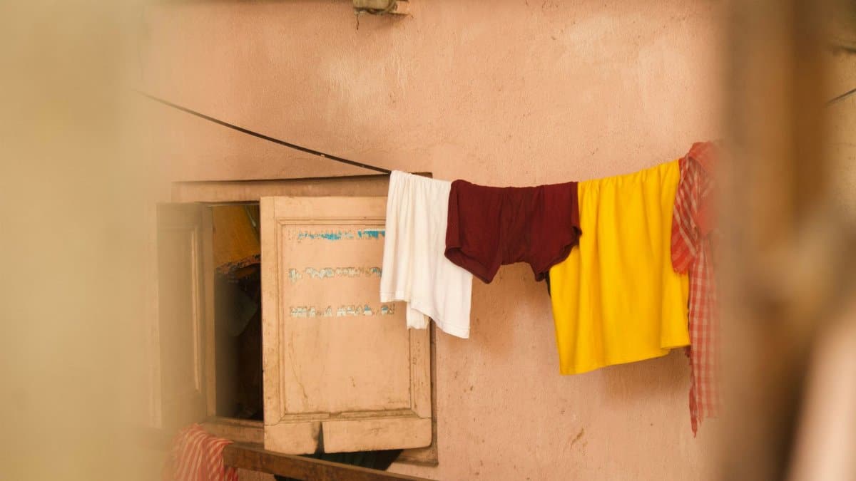 Bright clothes hanging on a string inside a rustic room, signifying daily life.