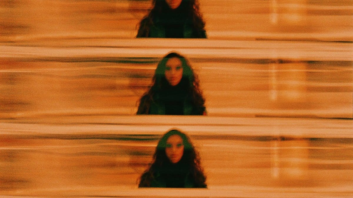 Repeat of unrecognizable female with long curly hair on abstract background with doble exposure in lights in night time outside