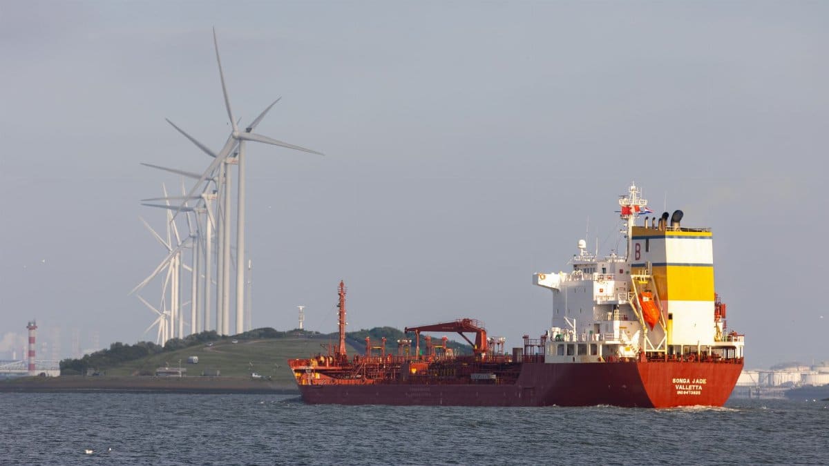 A cargo ship sailing near wind turbines in Hoek van Holland, reflecting modern industrial transport.
