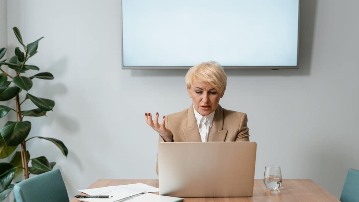 Professional businesswoman conducting a video conference call in a modern office setting.