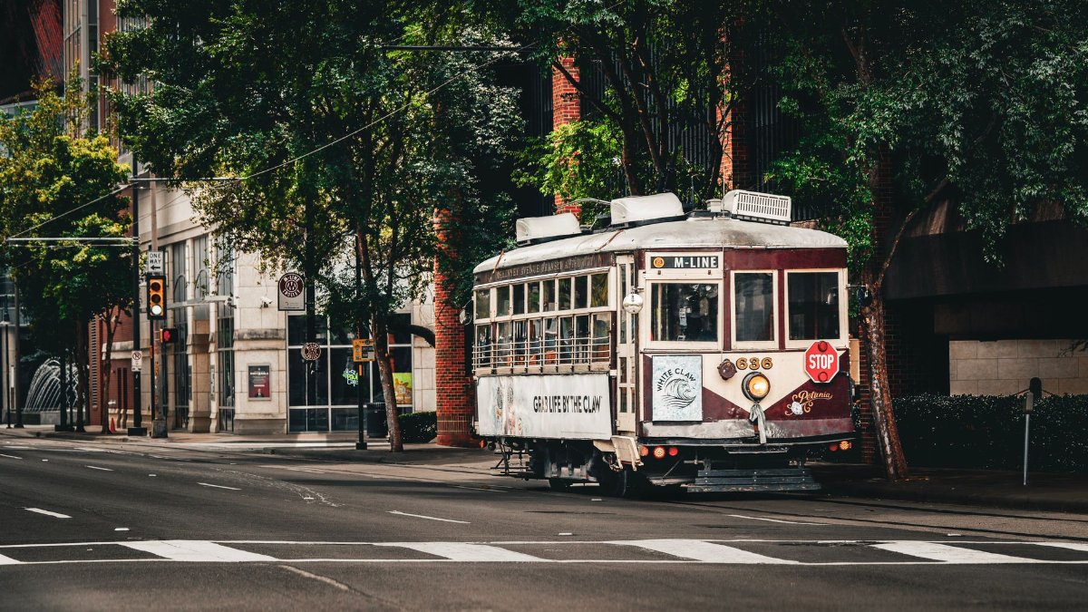 A charming vintage streetcar travels through the urban streets of Dallas, Texas, showcasing city life.