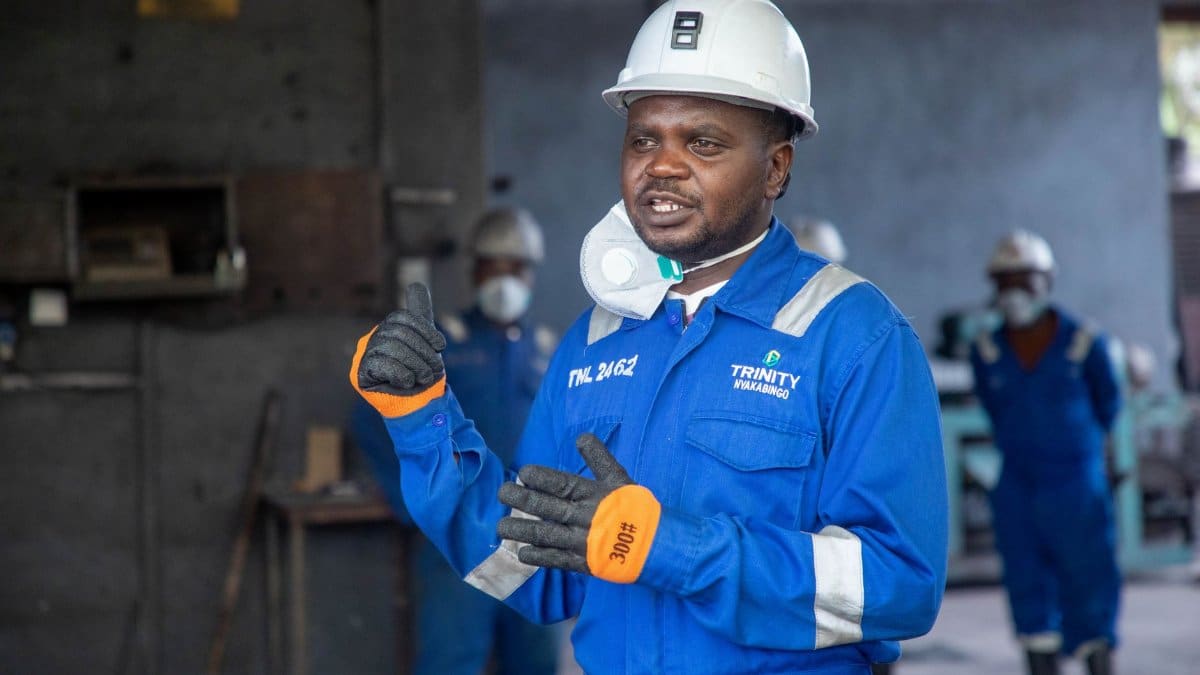 Engineer discussing safety procedures in an industrial factory setting, wearing full protective gear.