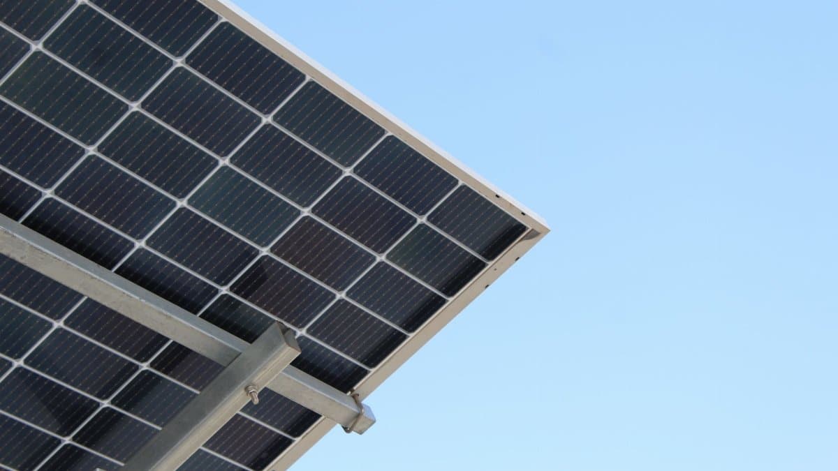 A modern solar panel with a clear blue sky background, highlighting renewable energy.