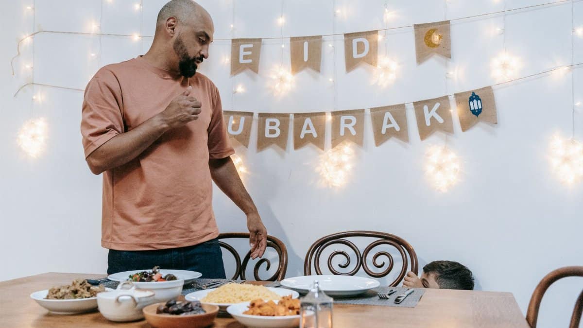 A family celebrating Eid indoors with festive meal and decorations, creating a joyful and warm atmosphere.