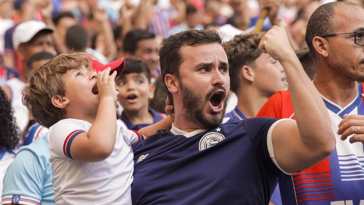 Energetic crowd cheering passionately at a live sports event, capturing excitement and unity.