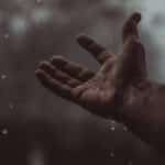 A close-up of a hand catching raindrops in Bahawalpur, embracing the rain's refreshing feel.
