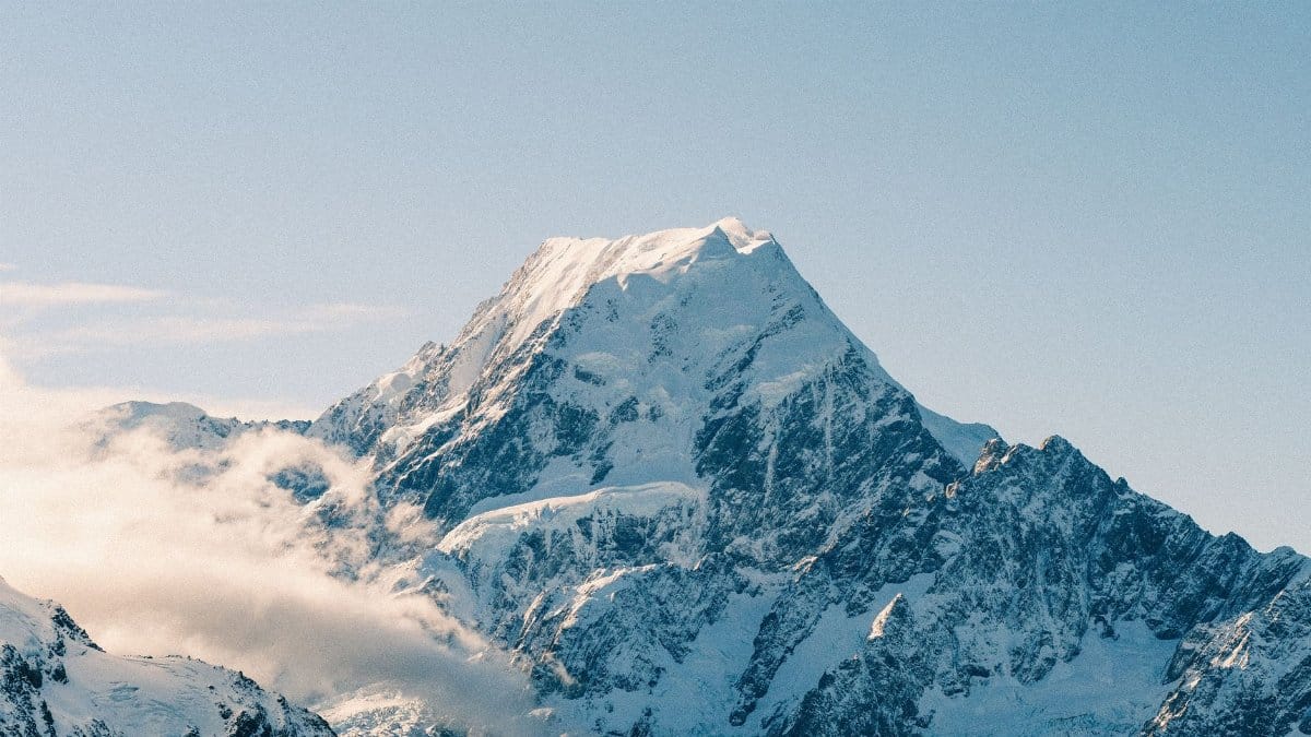 Pristine snow-covered Mount Cook under a clear sky in New Zealand's majestic landscape.