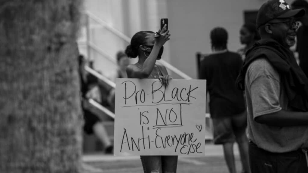A woman holds a 'Pro-Black is Not Anti-Everyone Else' sign at a protest in Brooksville, Florida.