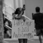 A woman holds a 'Pro-Black is Not Anti-Everyone Else' sign at a protest in Brooksville, Florida.