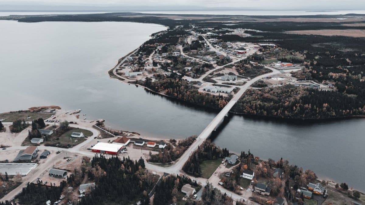 Aerial shot showcasing a scenic coastal town with a bridge connecting two sides over the water.