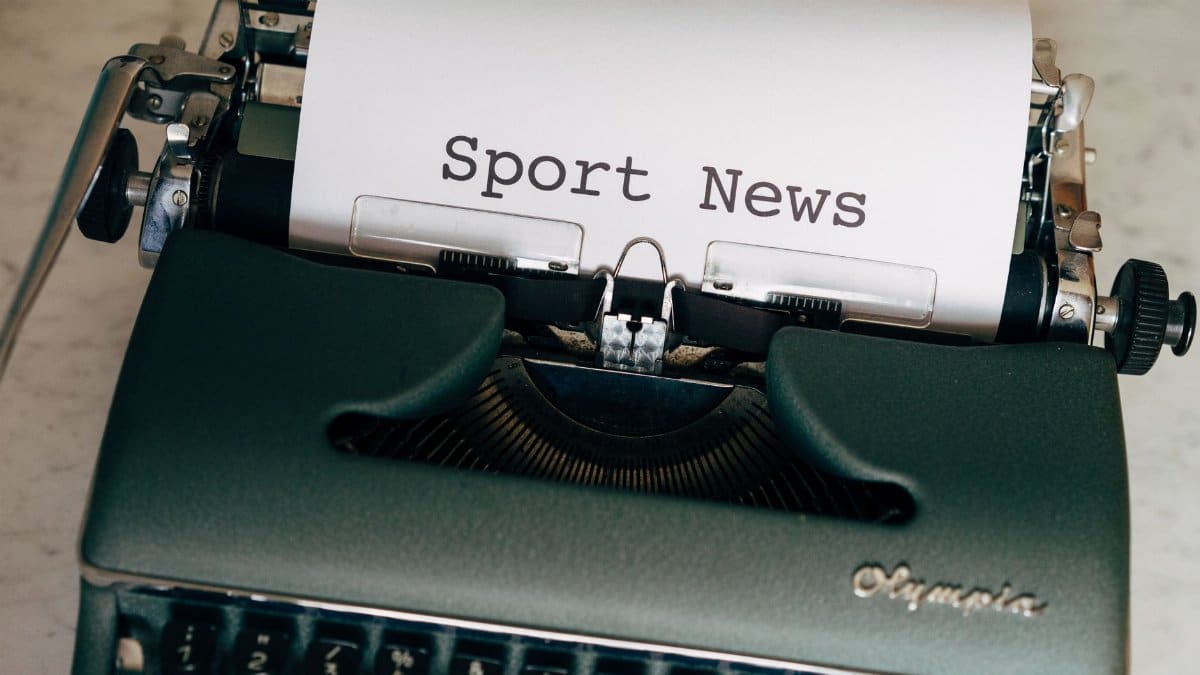Close-up of a vintage typewriter with a paper showing 'Sport News', evoking nostalgia and classic journalism.