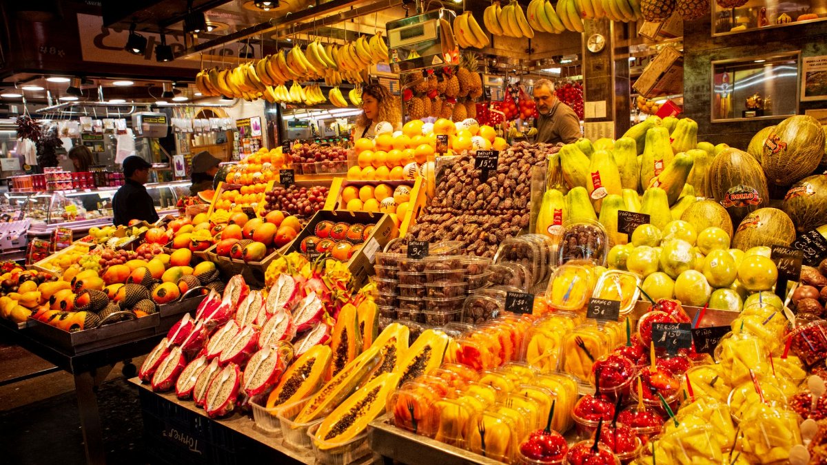 Colorful fresh fruit display at a lively local market stall, showcasing diverse produce.
