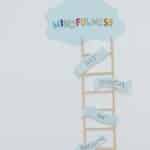 Creative mindfulness concept with ladder, words, and cloud shape for mental well-being.