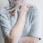 A woman metaphorically trapped in a spider web depicting anxiety and entrapment.