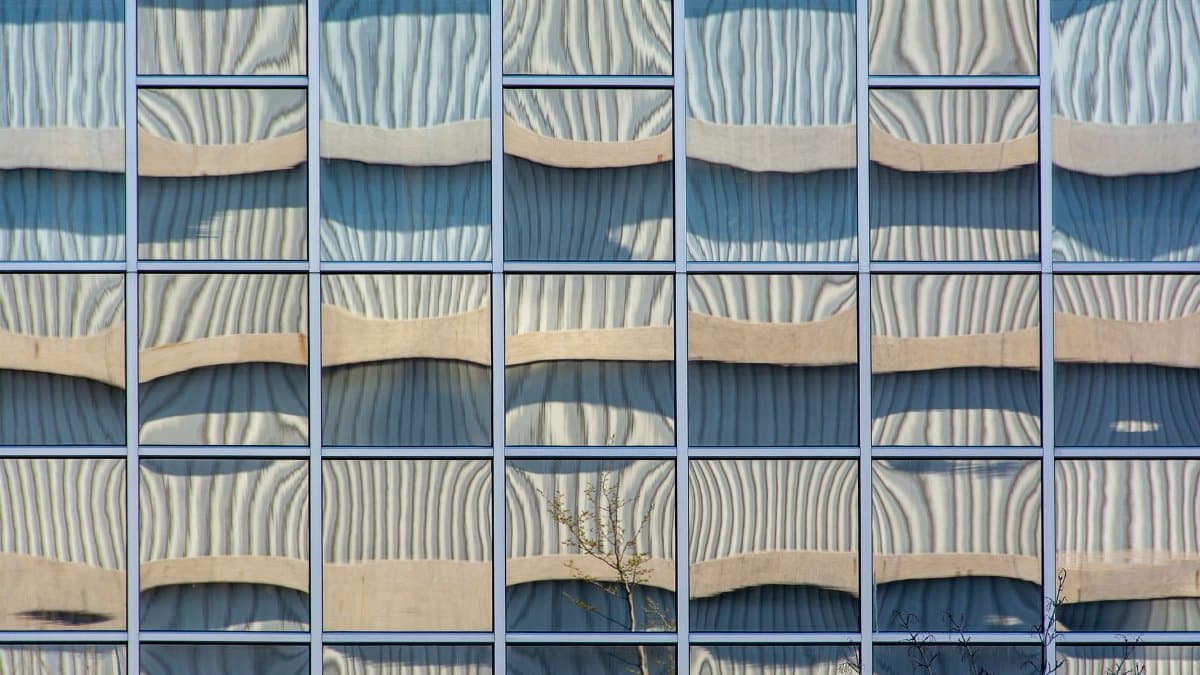 Creative reflection on a glass building facade showcasing abstract patterns and architectural design.