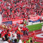 Cheerful fans at a college football game in Houston, TX, showcasing school spirit and vibrant energy.