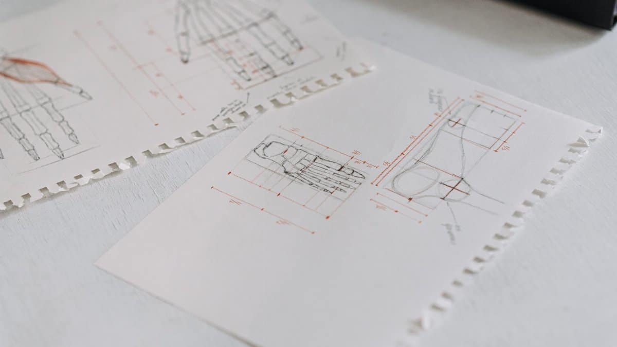 Close-up of detailed technical drawings on neatly arranged white paper sheets, highlighting design concepts.