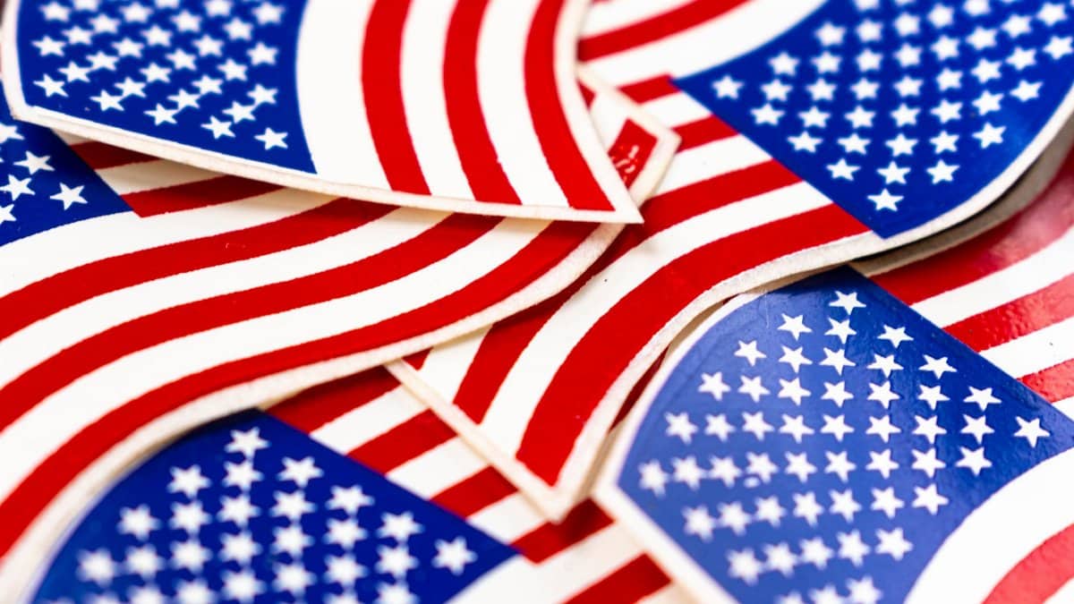 Bright close-up of overlapping American flag stickers, symbolizing patriotism and national pride.