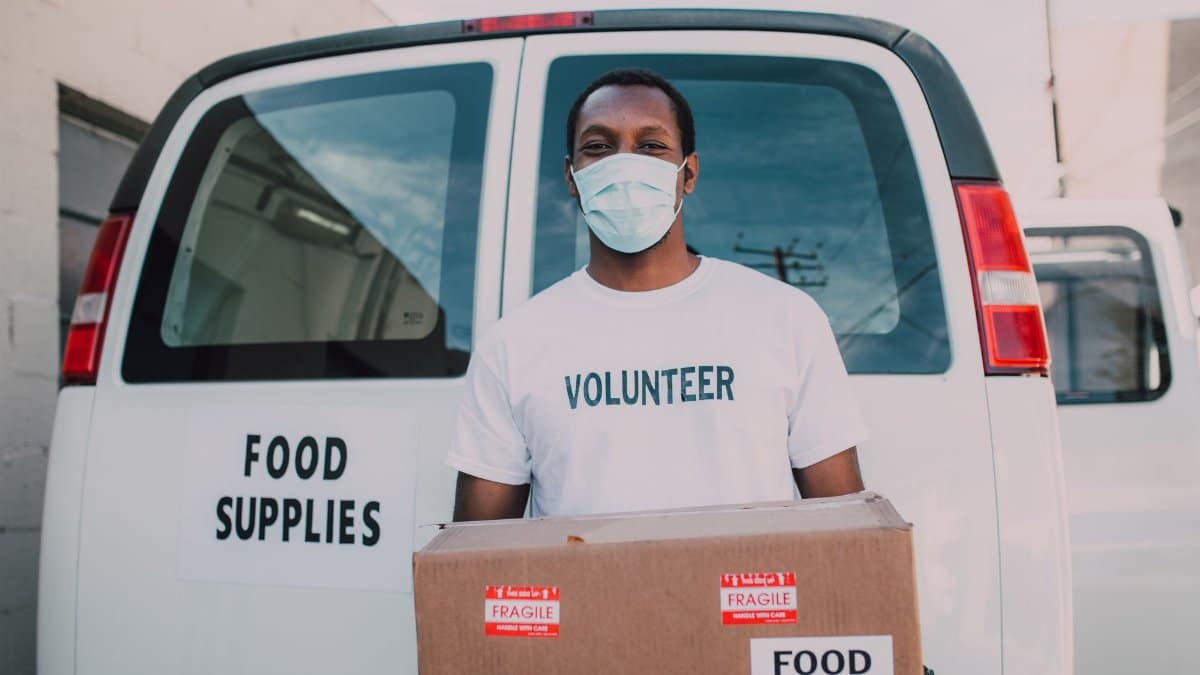 African American volunteer distributing food supplies during relief efforts.