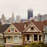 Iconic Painted Ladies in San Francisco with city skyline and fog.
