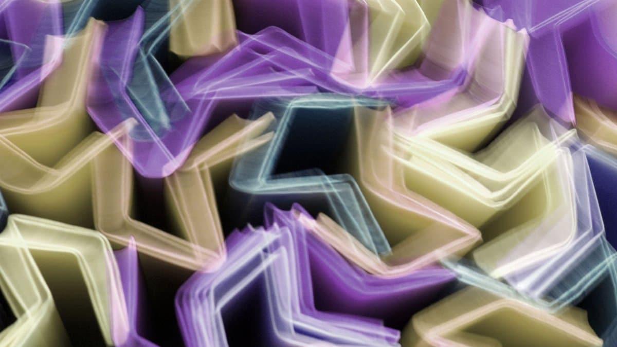 Dynamic abstract image featuring vibrant, colorful geometric shapes in motion blur, creating a lively visual rhythm.