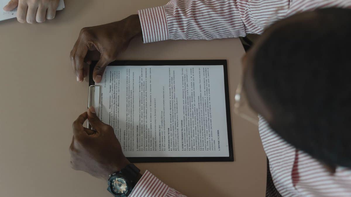 A close-up, overhead view of an individual holding a document during a business meeting.