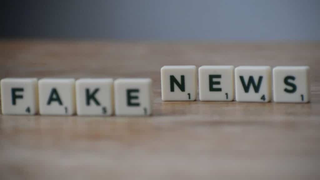 Scrabble tiles spelling 'Fake News' on a wooden surface highlighting misinformation.