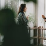 Side view of female workers in formal clothes discussing work issues and looking at each other