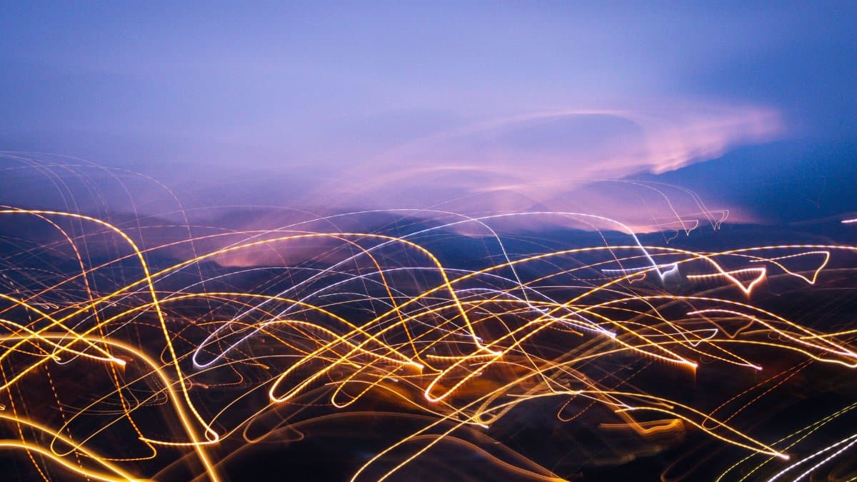 Dynamic abstract light trails in a vibrant night cityscape, evoking a sense of motion and energy.