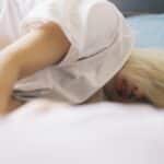 A woman with blonde hair lying on a bed, capturing a serene moment of relaxation.