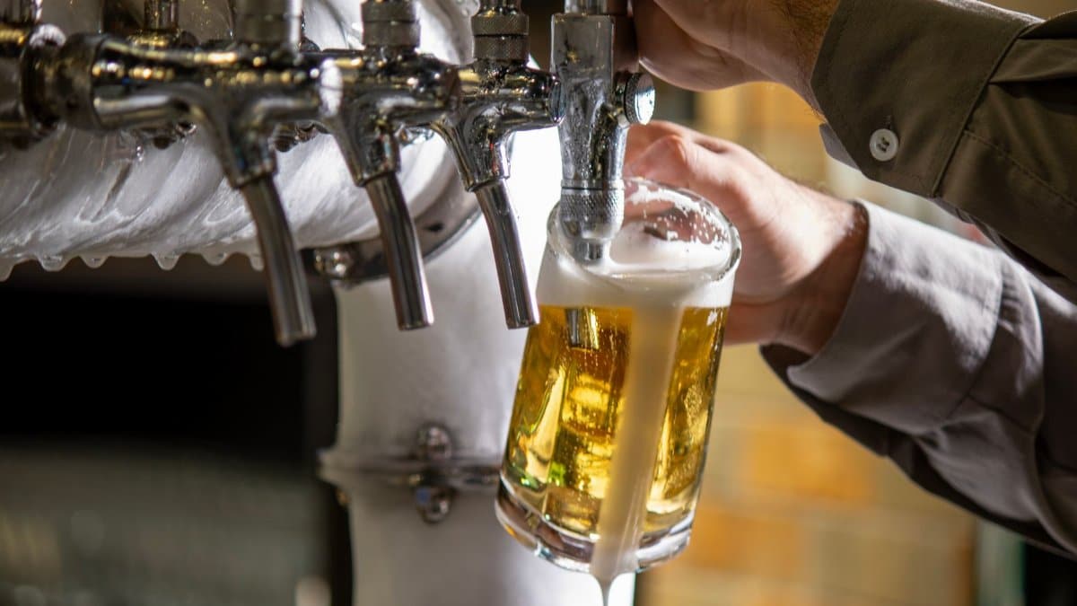 A bartender pours a refreshing glass of beer from a tap in a São Paulo bar.