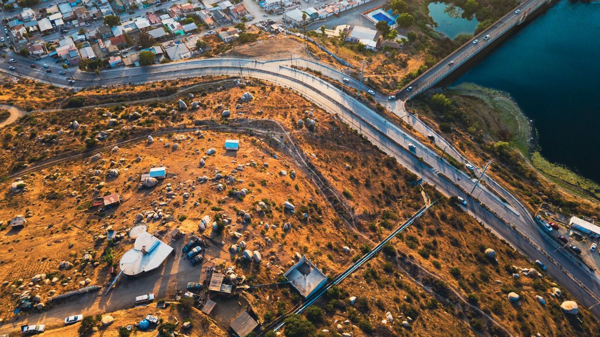 Aerial shot capturing urban and rural contrast with roads and lake.