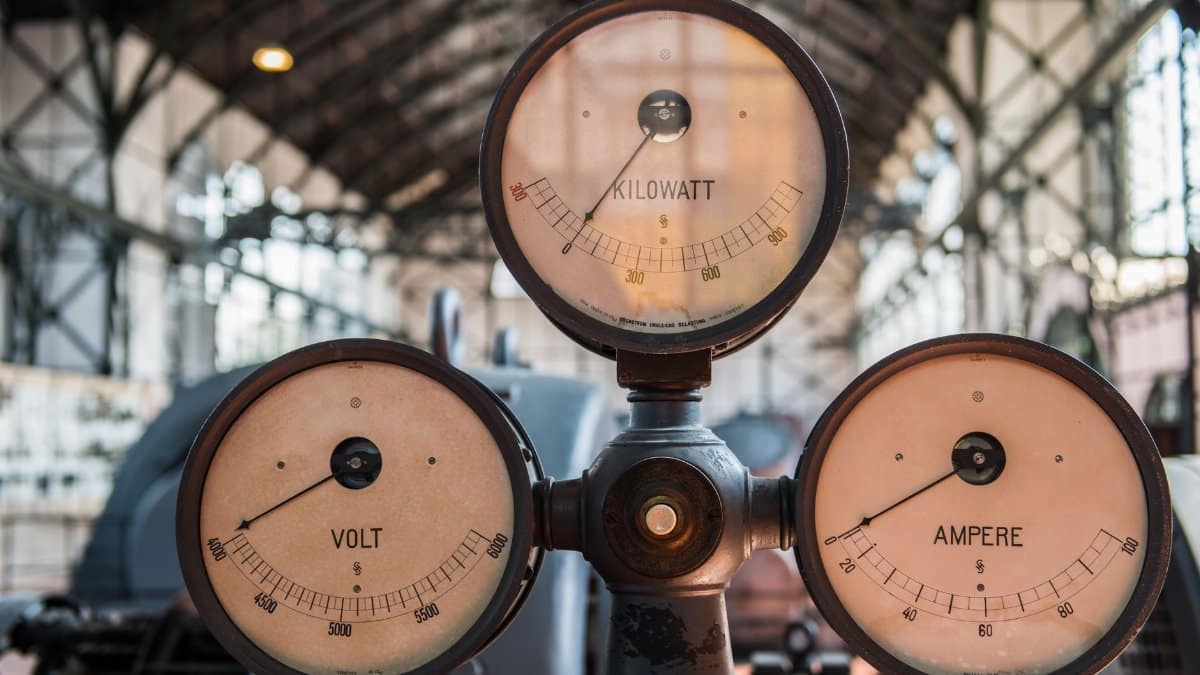 Close-up of vintage kilowatt, volt, and ampere gauges in Essen's industrial setting.