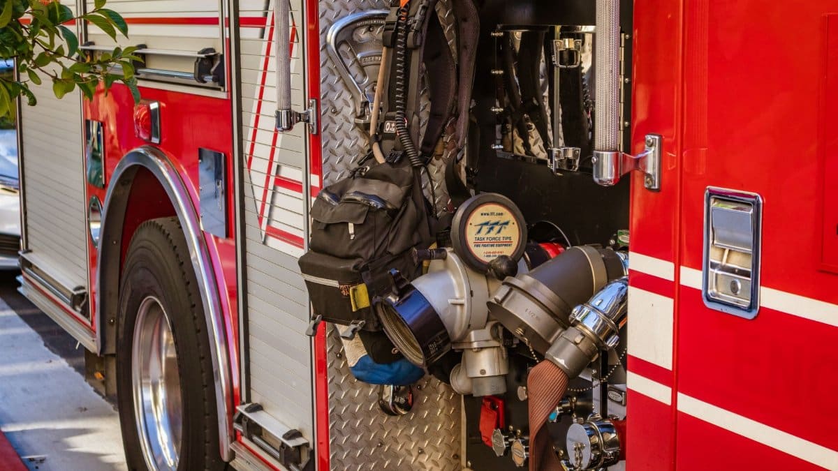 Close-up shot of a fire truck's open equipment compartment showcasing hoses and tools.