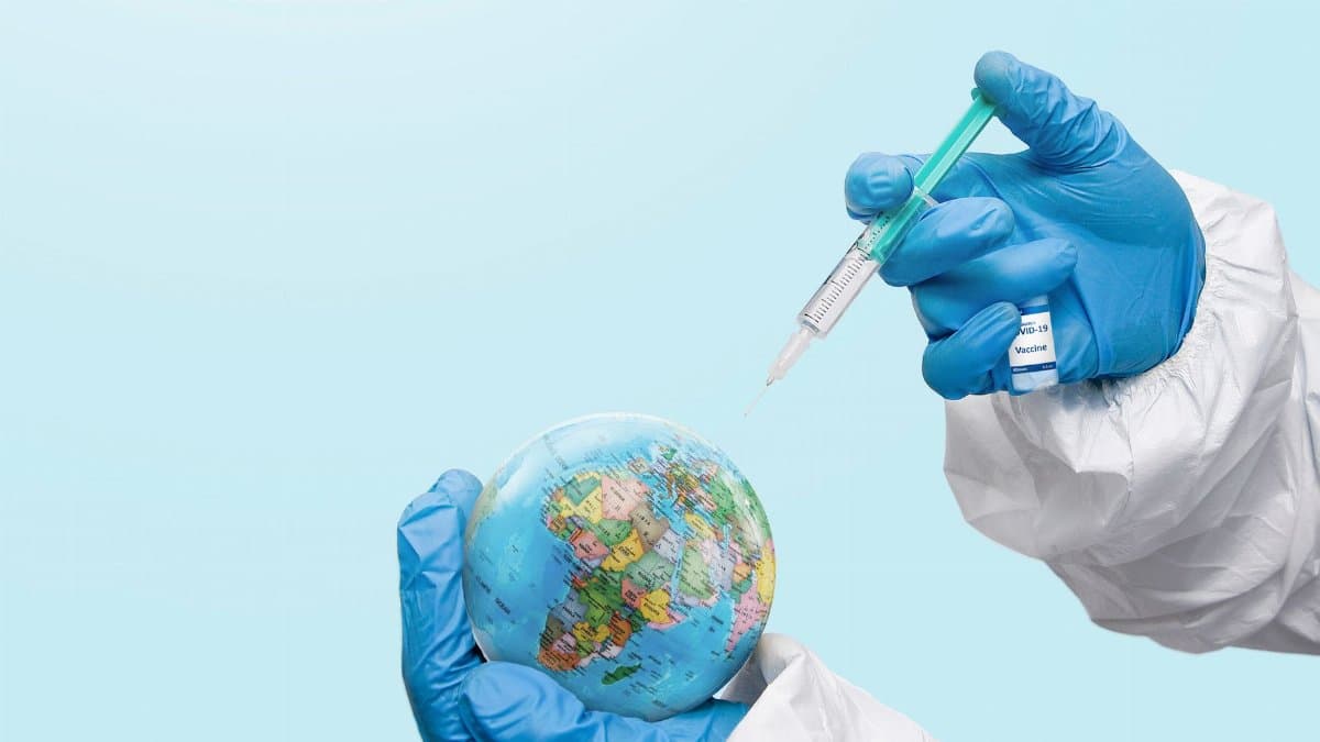 Hands in latex gloves injecting a globe with a syringe, symbolizing global vaccination efforts.