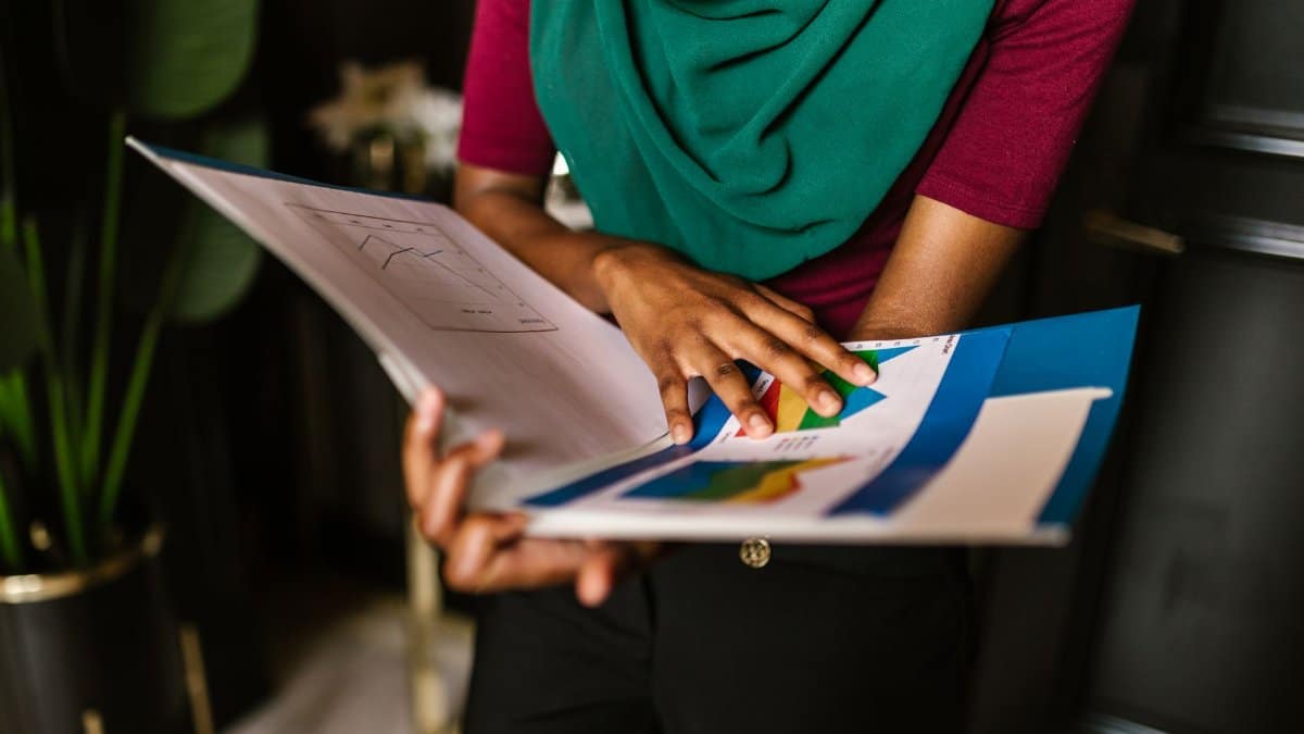 Close-up of a person reviewing charts and reports in an office setting.