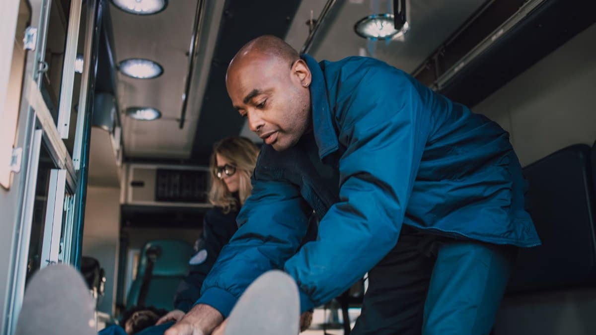 Paramedics attending to a patient inside an ambulance, showcasing emergency medical care.