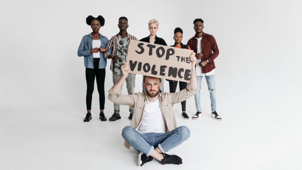 A group of people holding a sign advocating to stop violence, conveying unity.