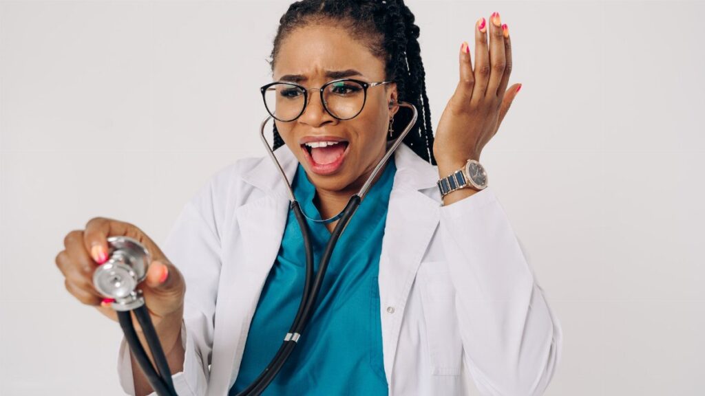 African American female doctor expressing surprise with a stethoscope in hand.