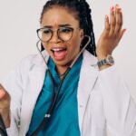 African American female doctor expressing surprise with a stethoscope in hand.